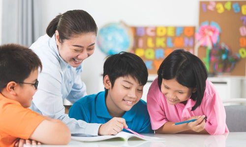 young-asian-teacher-helps-young-school-kids-class-1-1.jpg